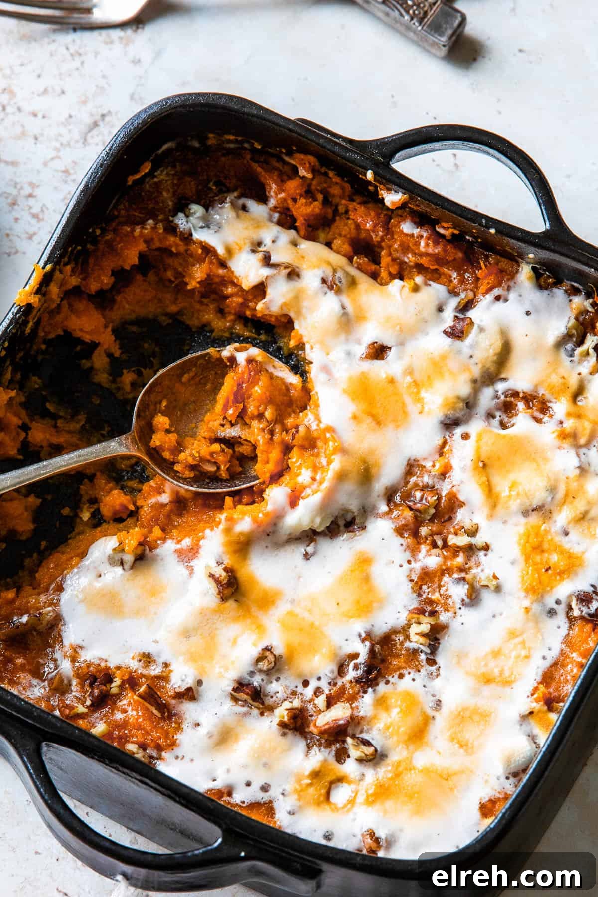 Sweet potato casserole with a spoon scooping out a portion.