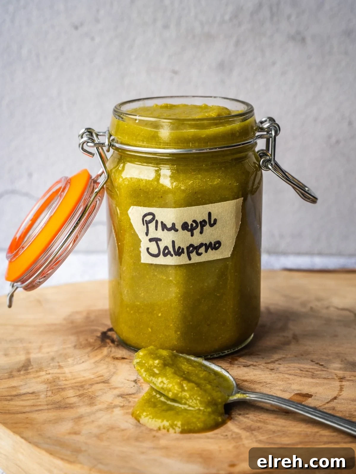 Fermented Pineapple Jalapeno Hot Sauce Recipe 2 A jar of hot sauce on a wooden board.