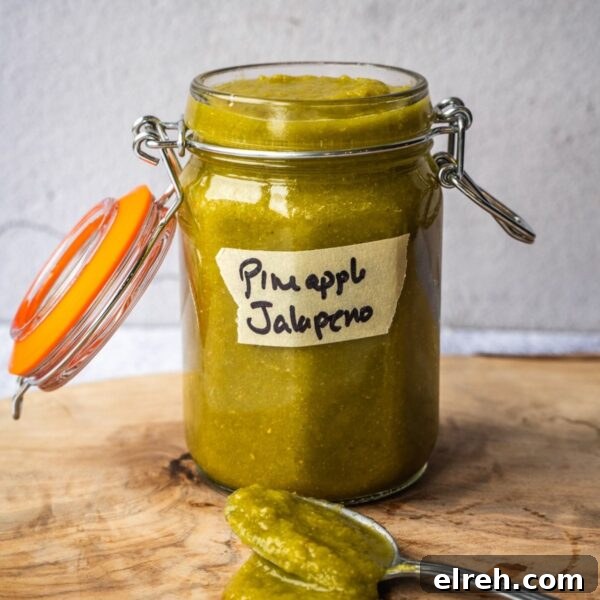 Fermented Pineapple Jalapeno Hot Sauce Recipe 9 A jar of hot sauce on a wooden board.