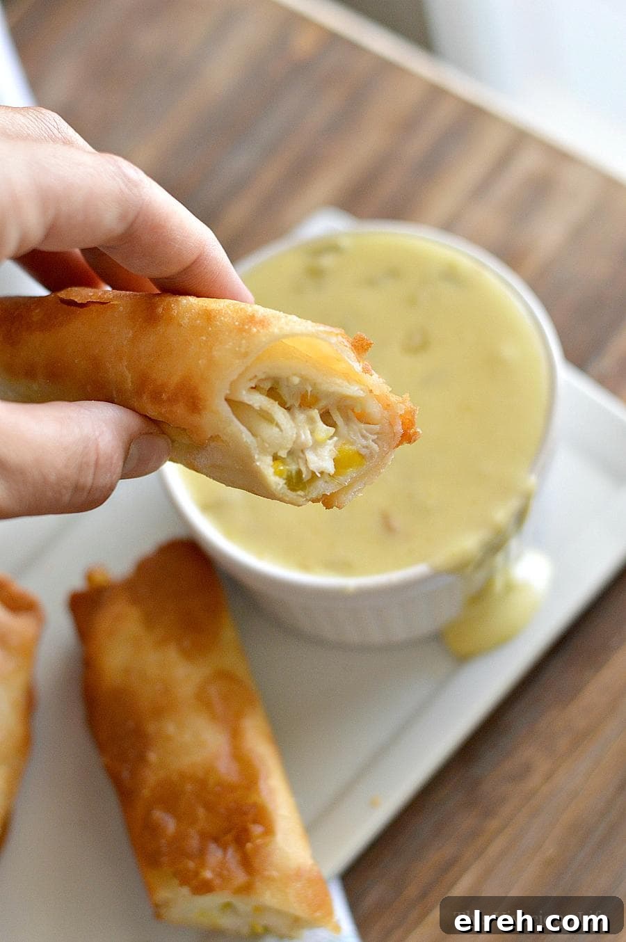 Rolled Tacos with Spicy Queso Sauce Rolled Tacos with queso being dipped