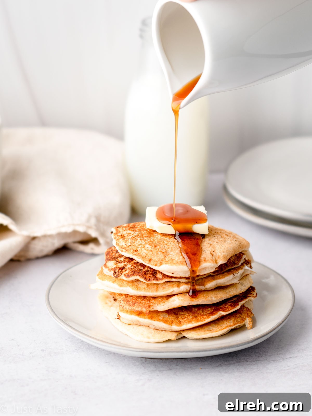 Fluffy Gluten Free Pancakes From Scratch 2 Stack of gluten free pancakes with syrup being poured on top.