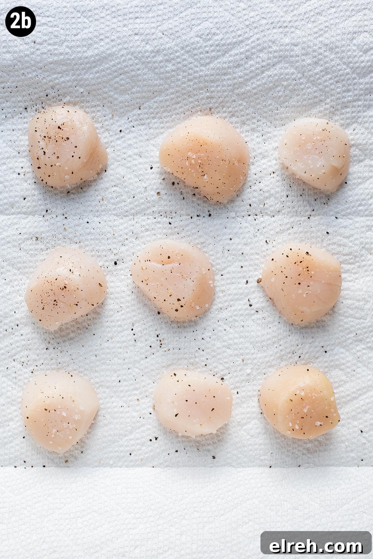 Sweet and Smoky Bacon Wrapped Scallops 5 Seasoned raw sea scallops with salt and pepper on a sheet of paper towel.