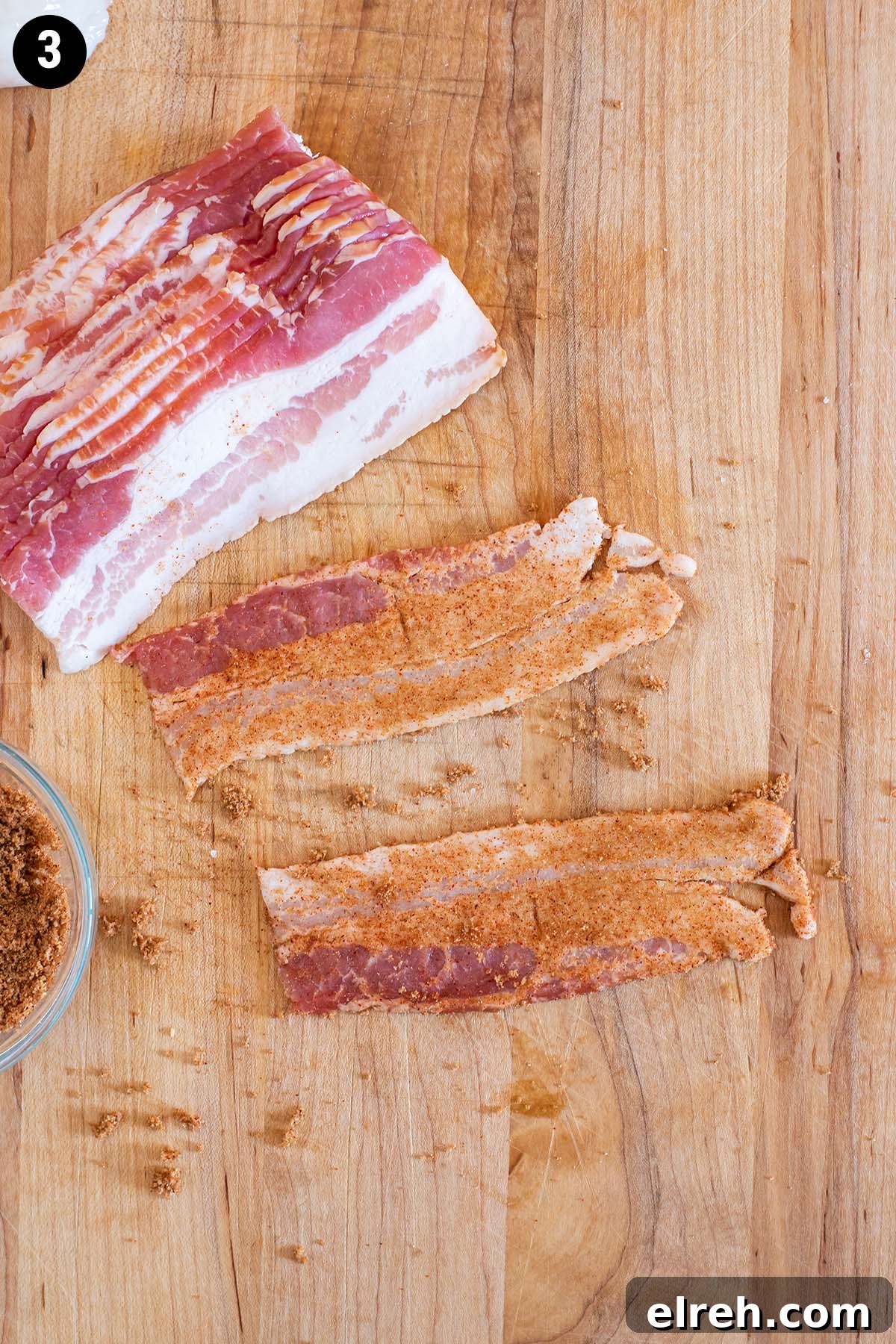 Sweet and Smoky Bacon Wrapped Scallops 6 Half slices of raw bacon rubbed with brown sugar and paprika on a wooden cutting board.