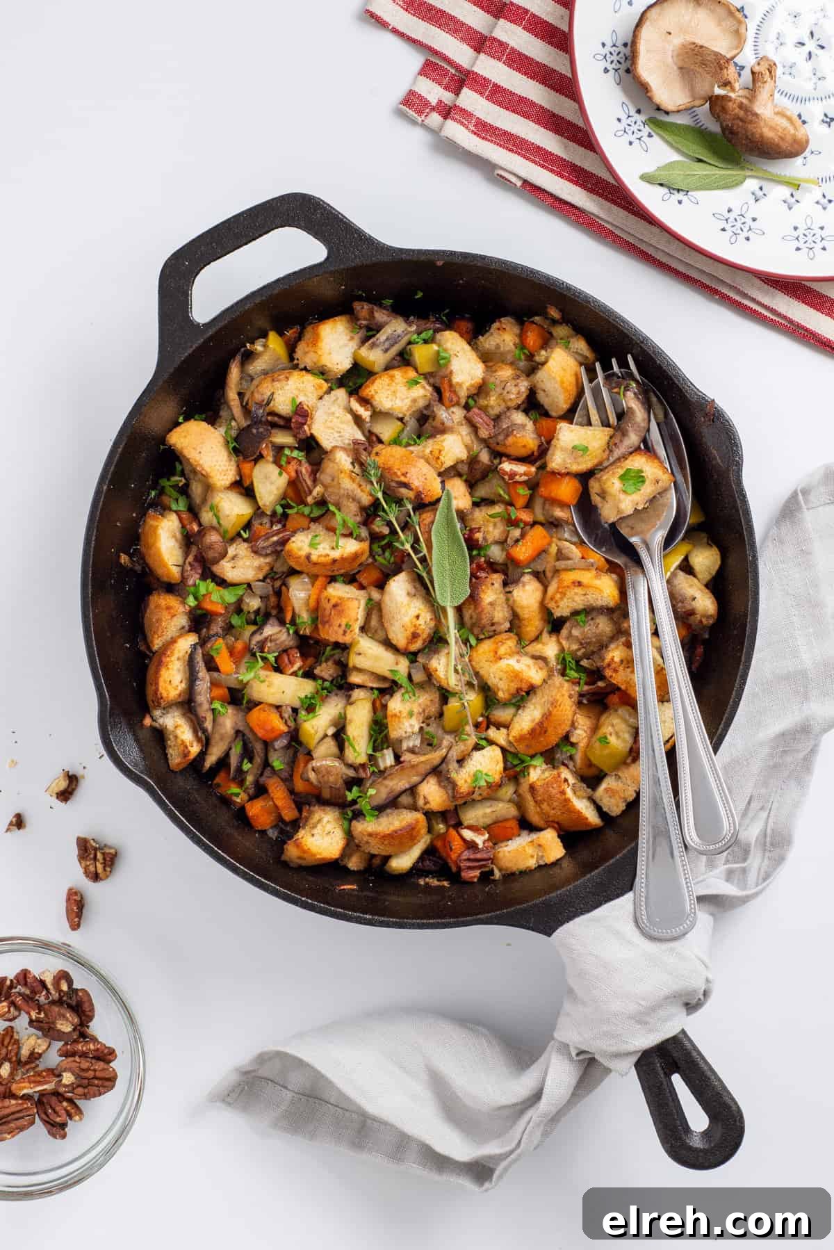 Classic Vegan Stuffing with Herbs and Cranberries 10 Overhead view of skillet with stuffing and two spoons in it.