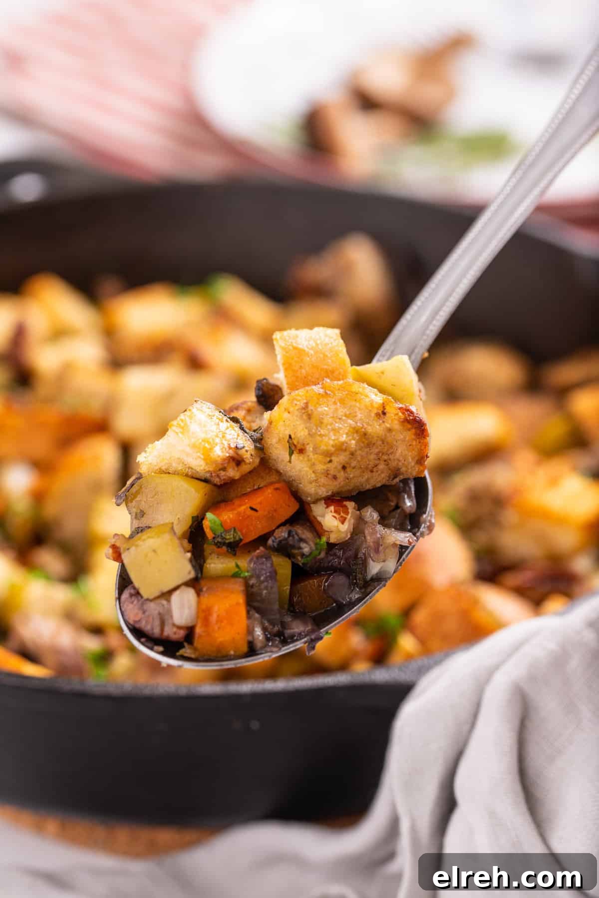 Classic Vegan Stuffing with Herbs and Cranberries 9 Close up of spoonful of stuffing over the skillet.