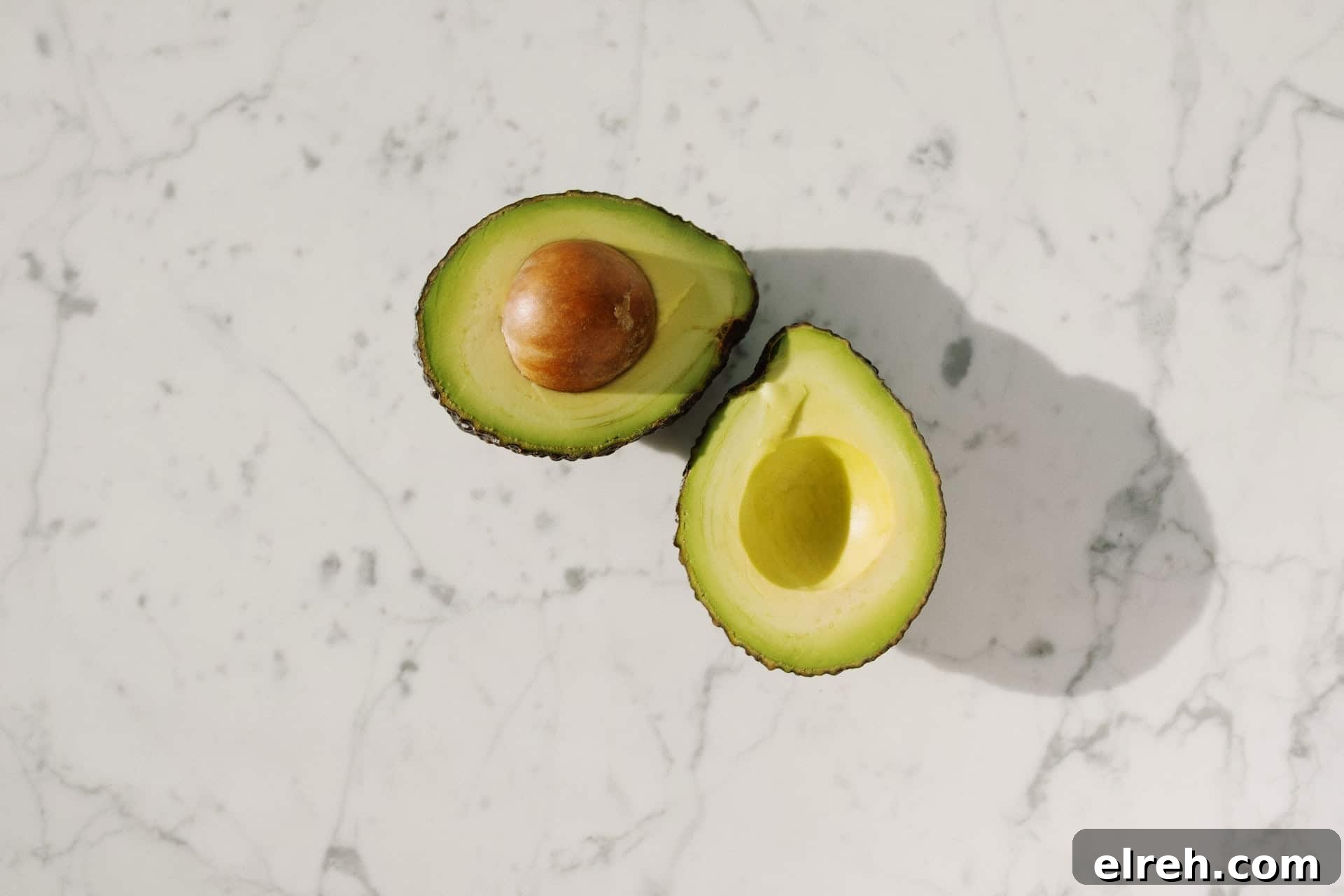 avocado sliced in half with the pit