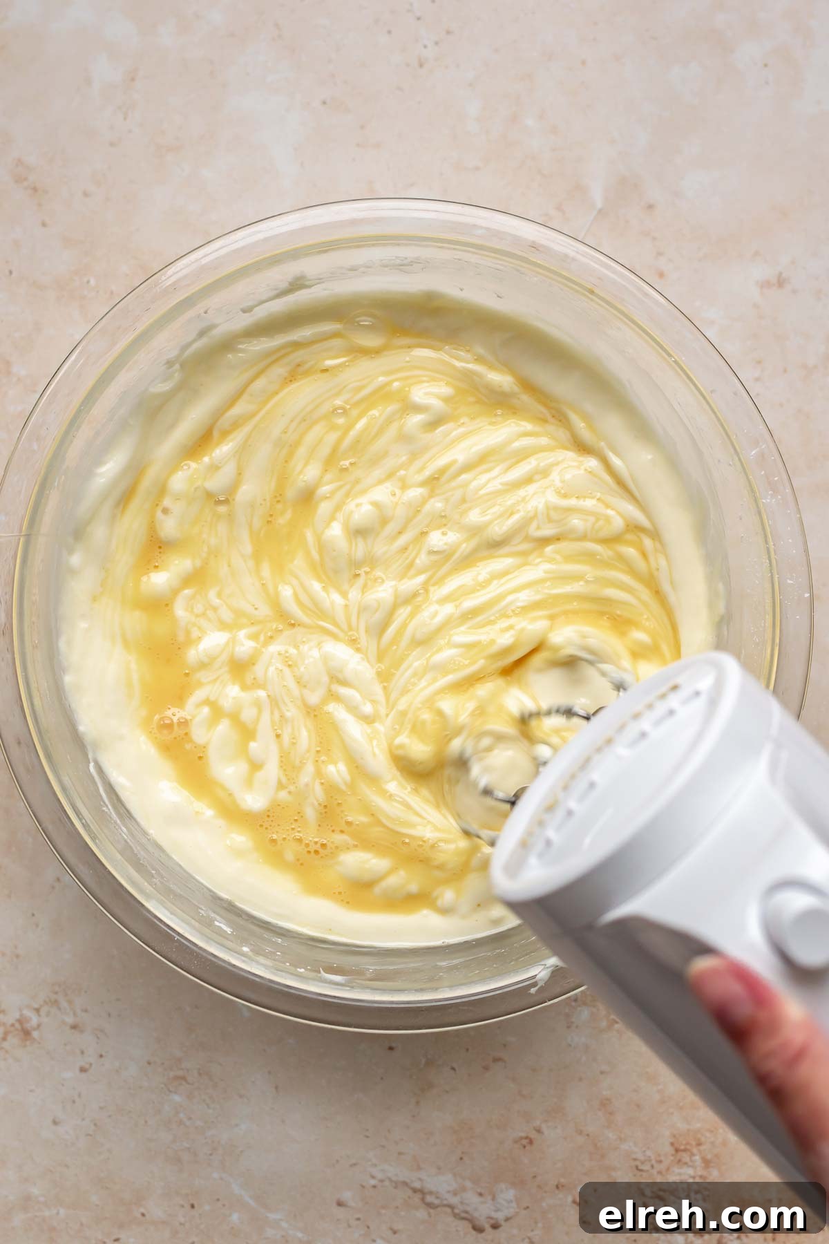 Apple Crumble Cheesecake with Cinnamon Streusel Recipe 13 A mixer beats whisked eggs into cheesecake batter.