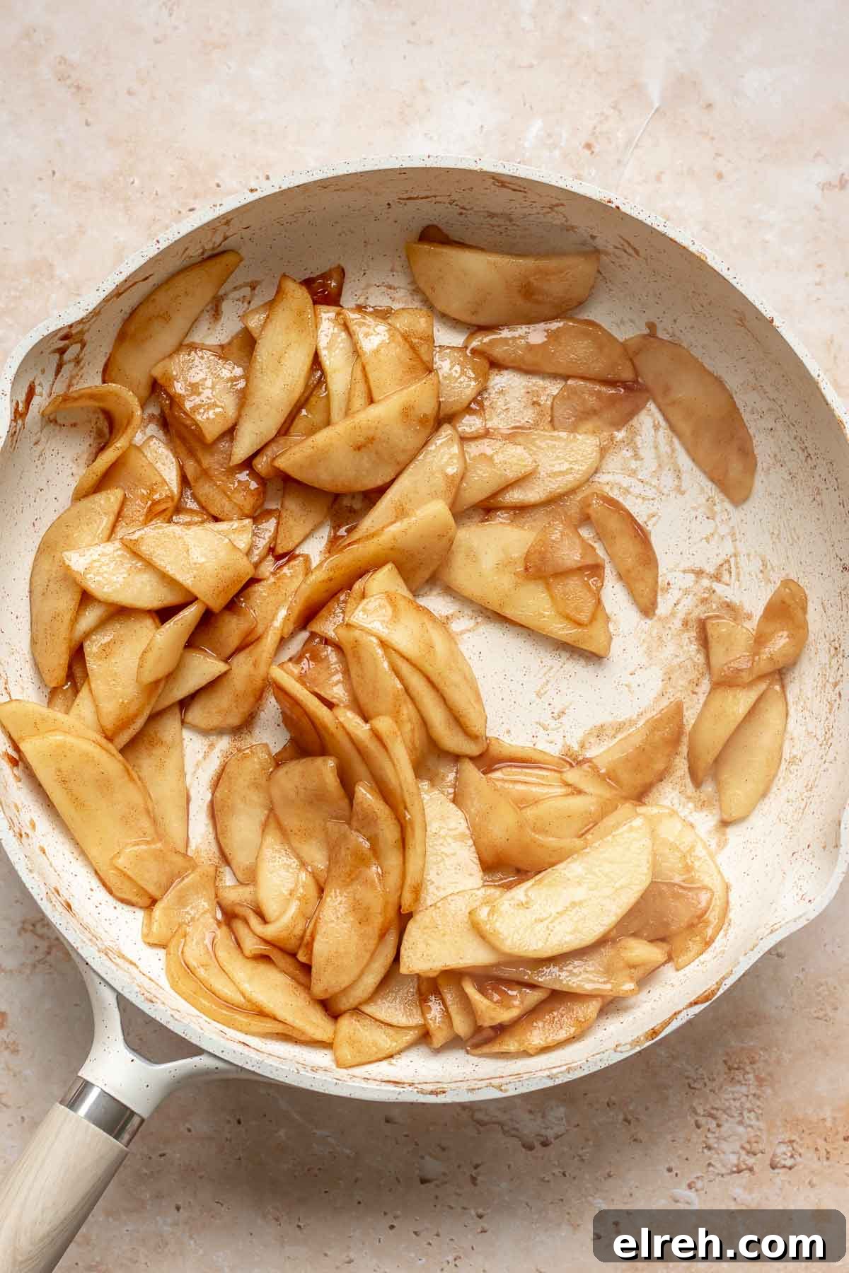 Apple Crumble Cheesecake with Cinnamon Streusel Recipe 6 Cooked apple slices in a frying pan.