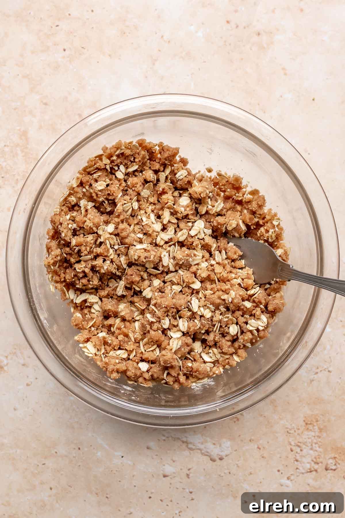 Apple Crumble Cheesecake with Cinnamon Streusel Recipe 10 Crumble topping mixed in a bowl with a fork.