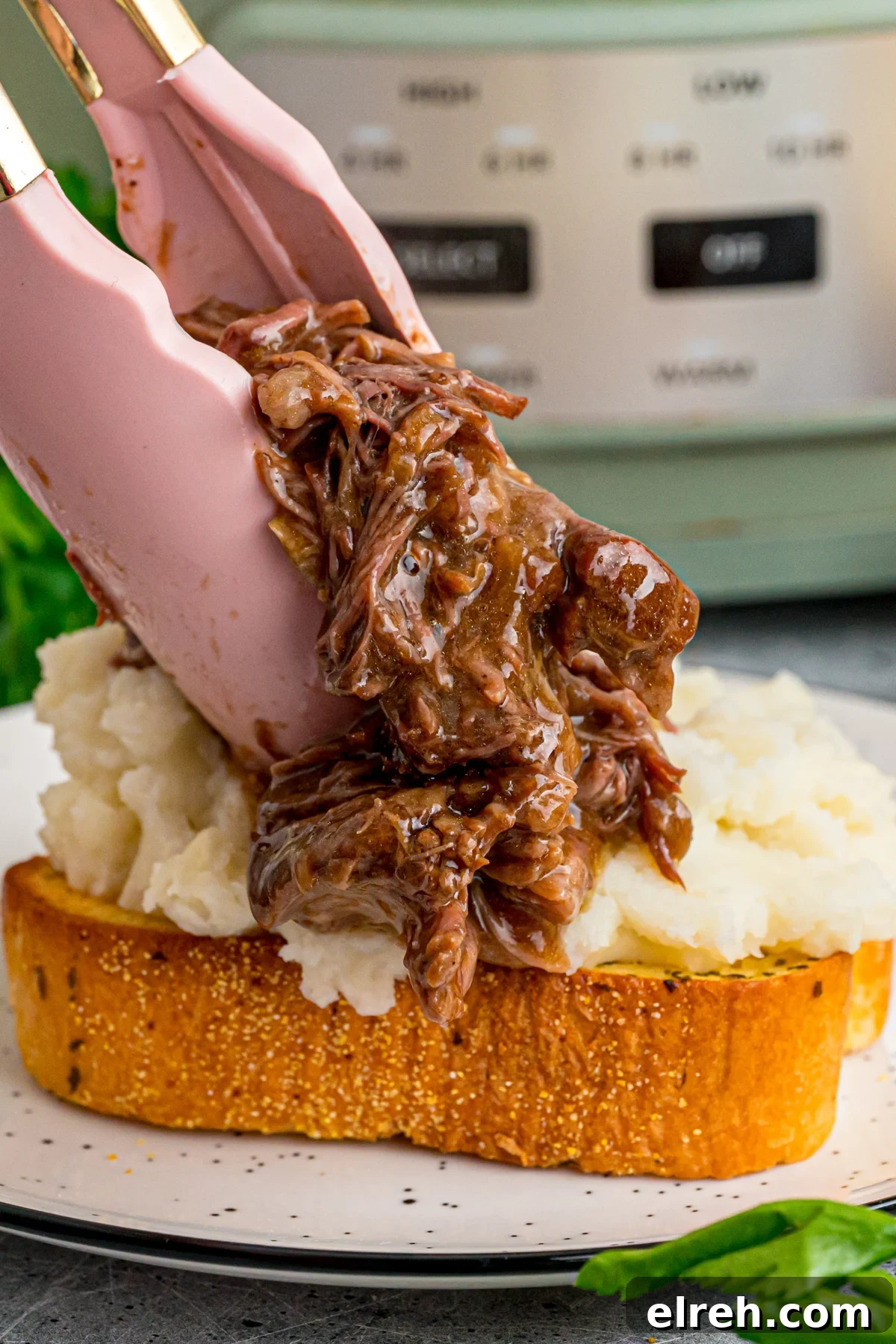 Open Faced Roast Beef Manhattan Sandwich with Gravy 6 Tongs placing shredded beef on top of mashed potatoes on Texas toast.