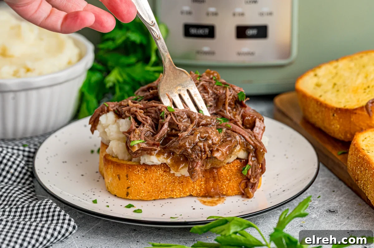 Open Faced Roast Beef Manhattan Sandwich with Gravy 8 A fork cutting into a piece of beef manhattan toast.
