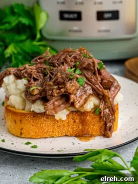Open Faced Roast Beef Manhattan Sandwich with Gravy 9 A serving of beef manhattan on a plate in front of a crockpot.