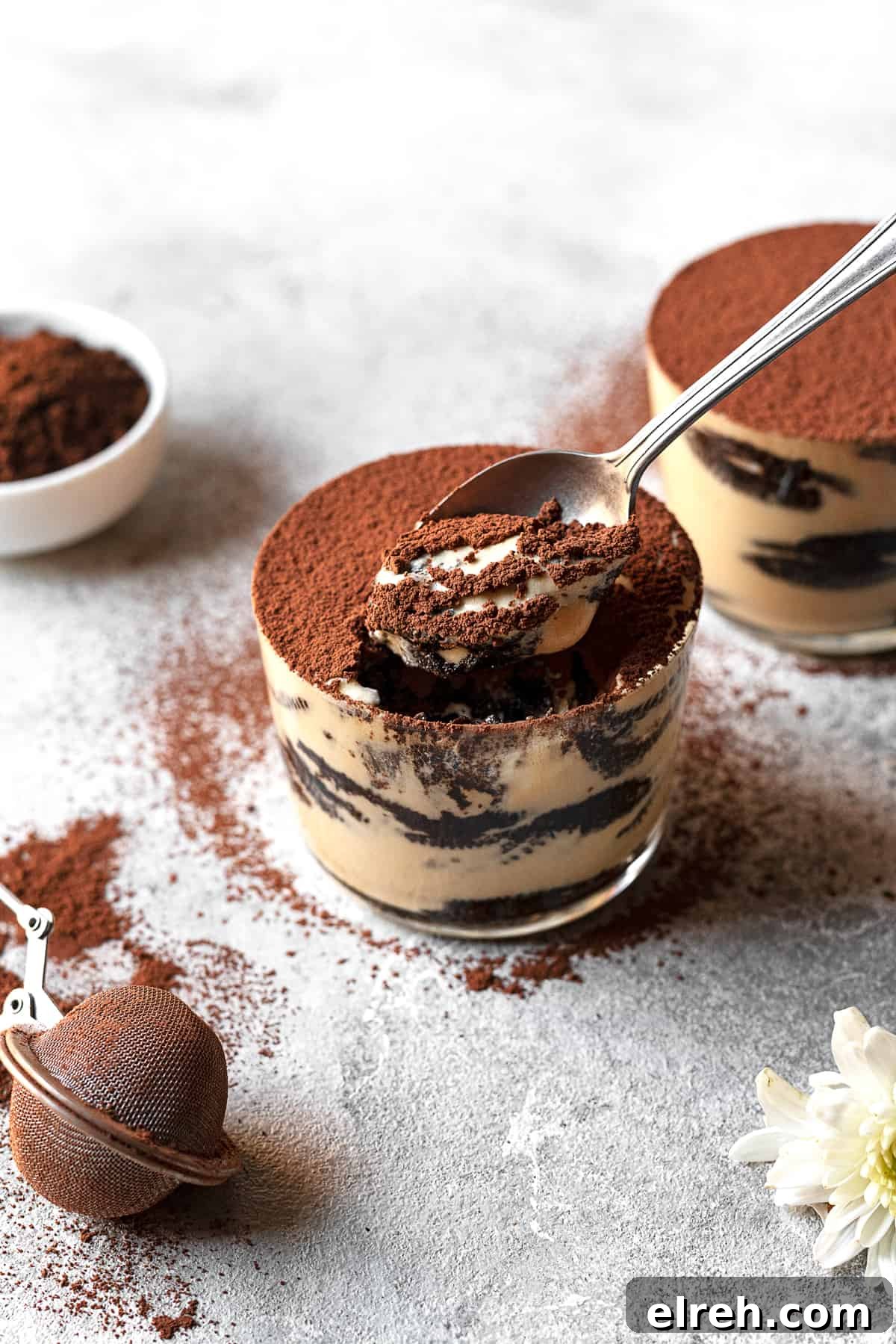 two jars of Oreo tiramisu with a spoon taking a scoop from one