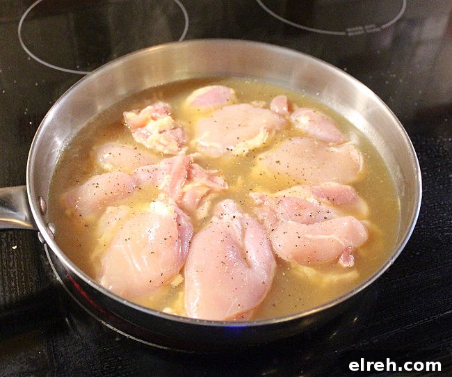 Apple Juice Glazed Chicken Thighs Recipe 5 Chicken thighs in a pan on a black electric stove.