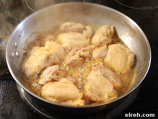 Apple Juice Glazed Chicken Thighs Recipe 7 Chicken cooking in apple juice in a pan on the stove.
