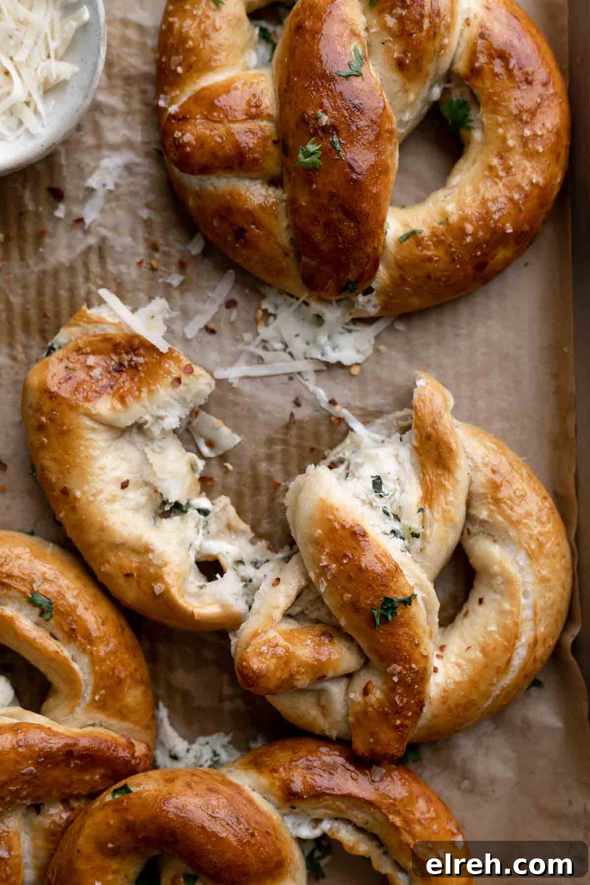 spinach artichoke stuffed pretzel ripped in half to show the filling.