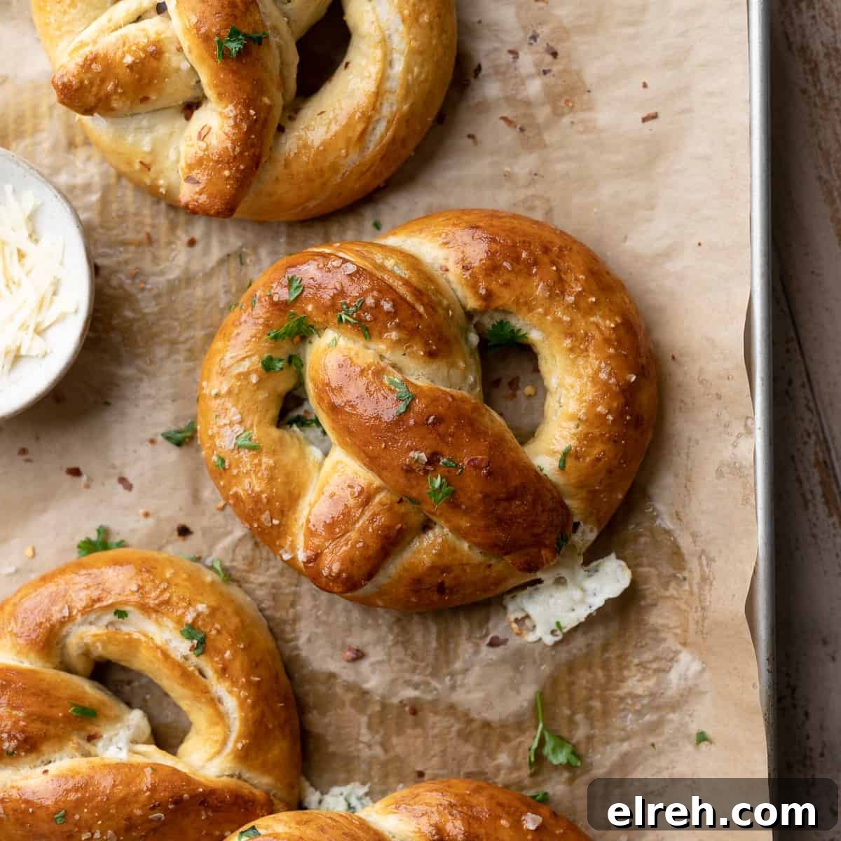 stuffed pretzels brushed with butter on a baking tray.