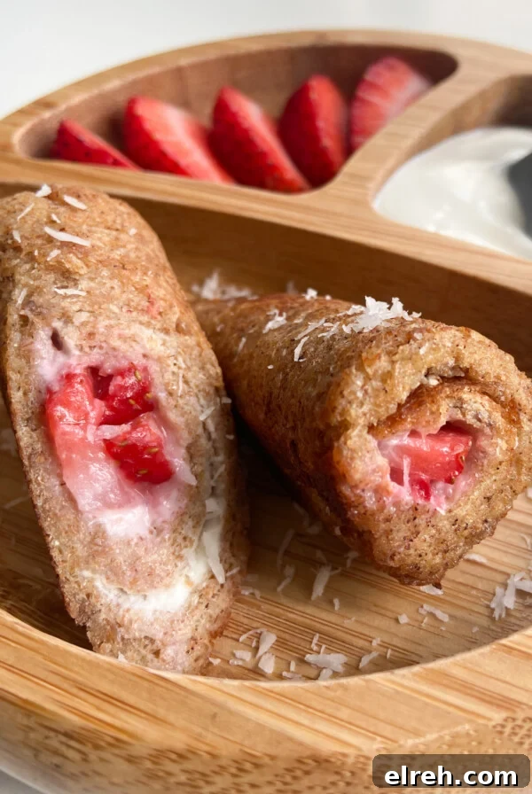 Strawberry cheesecake rollups served with sliced strawberries and yogurt