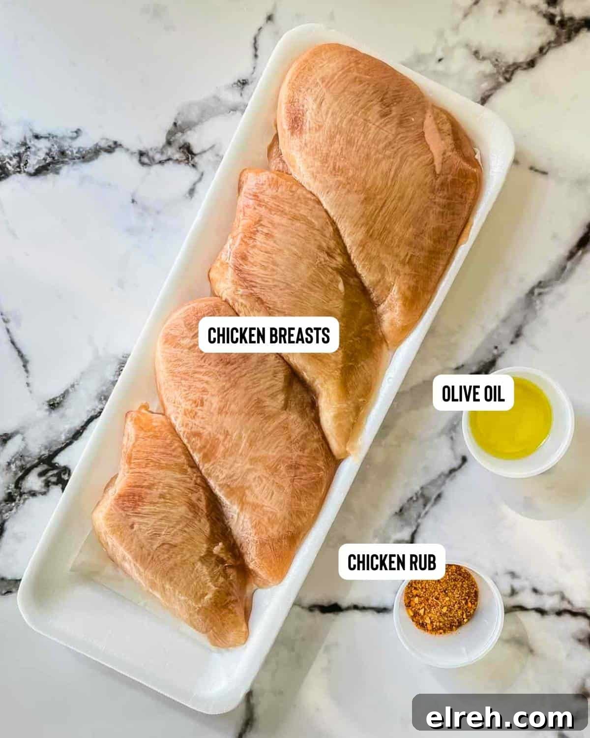 How to Cook Frozen Chicken Breasts in an Air Fryer 3 Ingredients for frozen chicken breasts in the air fryer on a white table.