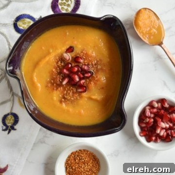 soup in purple bowl with copper spoon and dukkah and arils