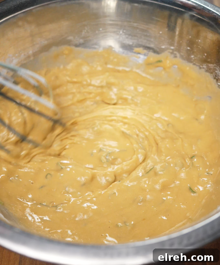 How to Make Mochiko Chicken: Crispy Hawaiian Fried Chicken 4 Using a whisk to combine mochiko batter ingredients until smooth and well incorporated in a metal mixing bowl.