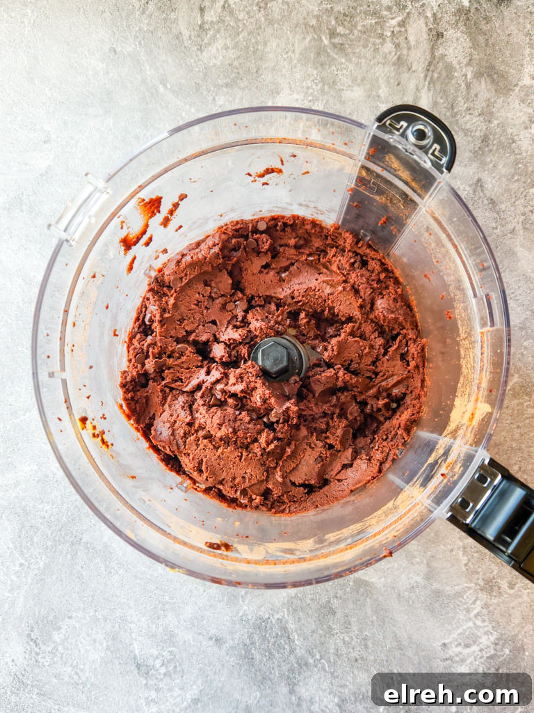 a food processor is filled with a fudgy brownie batter.