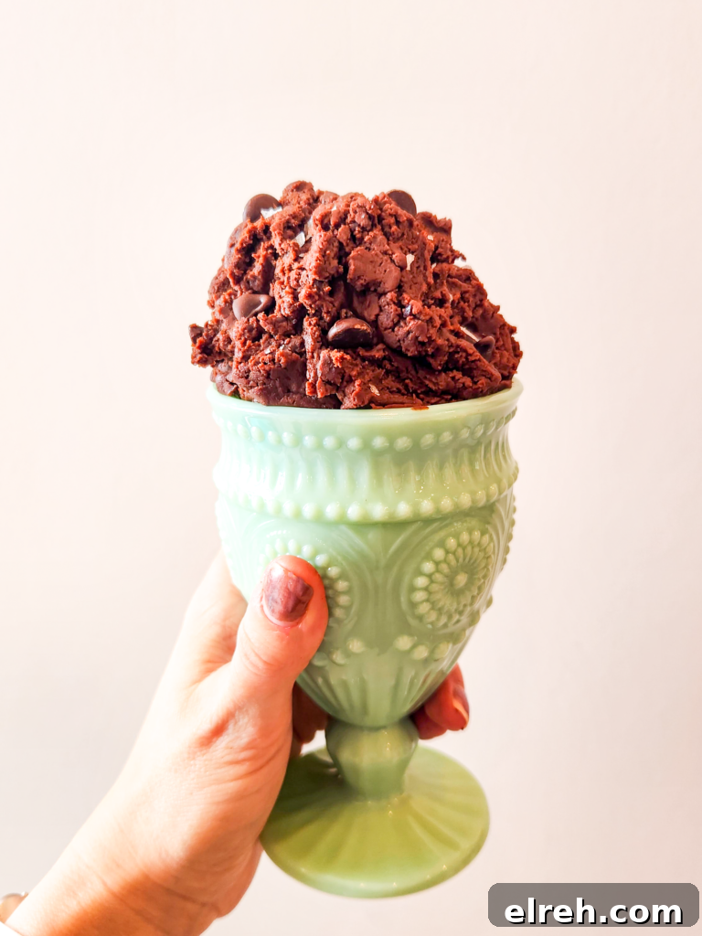 Brownie batter is piled high in a green blown glass sundae cup.