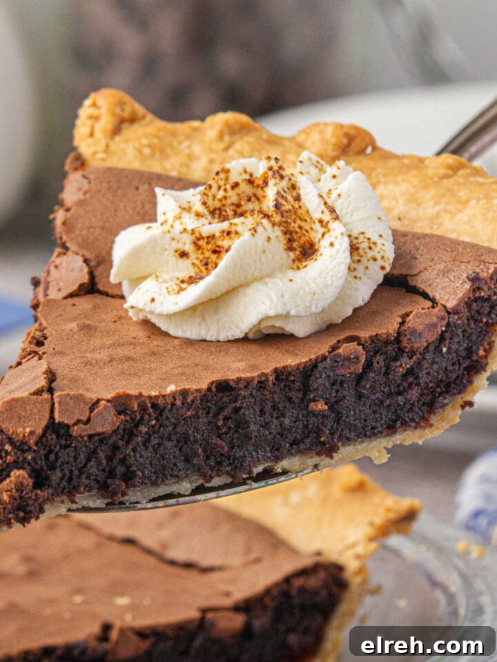 A slice of southern chocolate chess pie being lifted out of the pie dish.
