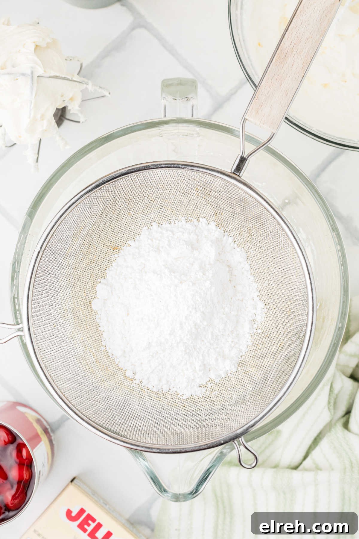 Powdered sugar being passed through a sieve.