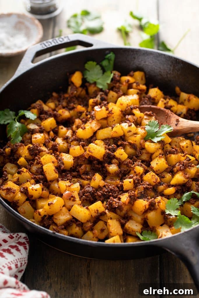 A cast iron skillet filled with tender potatoes and chorizo tossed together.