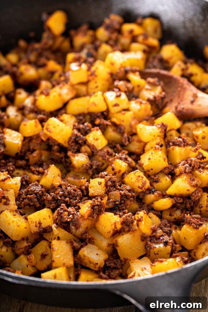 Close up view of papas con chorizo in a skillet.