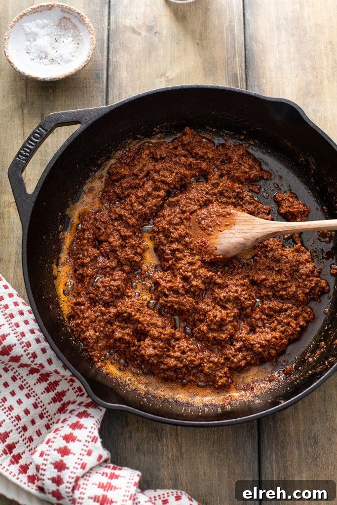 Chorizo being cooked in a skillet over medium-high heat.