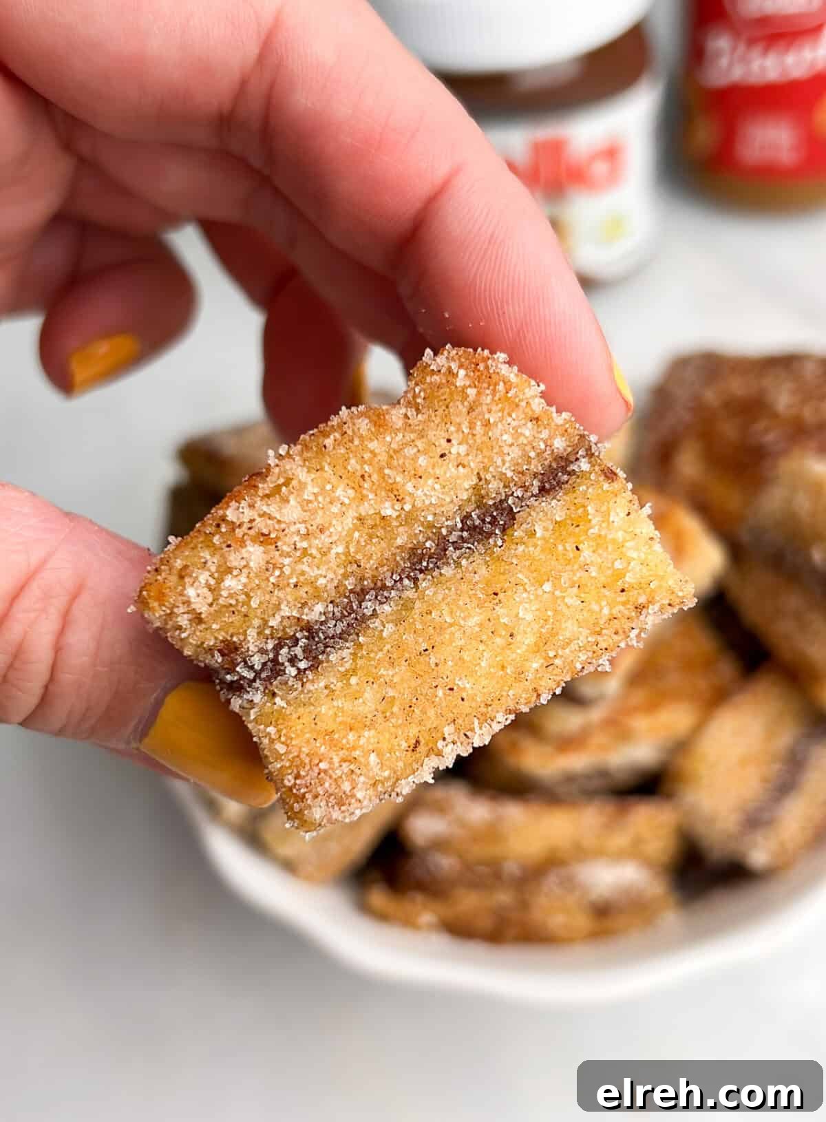Cream Cheese Stuffed French Toast Bites with Maple Syrup 3 mini stuffed french toast bites in hand