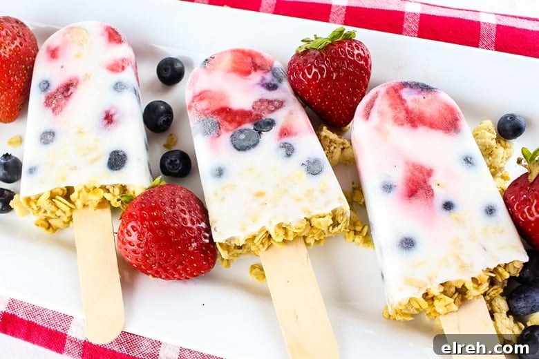Breakfast yogurt popsicles packed with berries and granola.