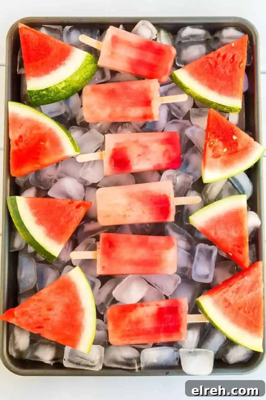 Watermelon popsicles on ice with fresh watermelon slices.