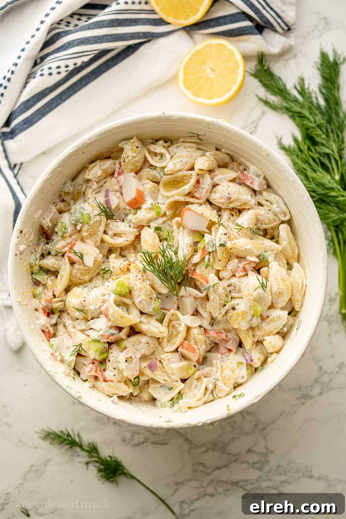 Creamy Crab and Pasta Salad with Lemon Dill Dressing 9 Crab salad in bowl near lemon and fresh dill.