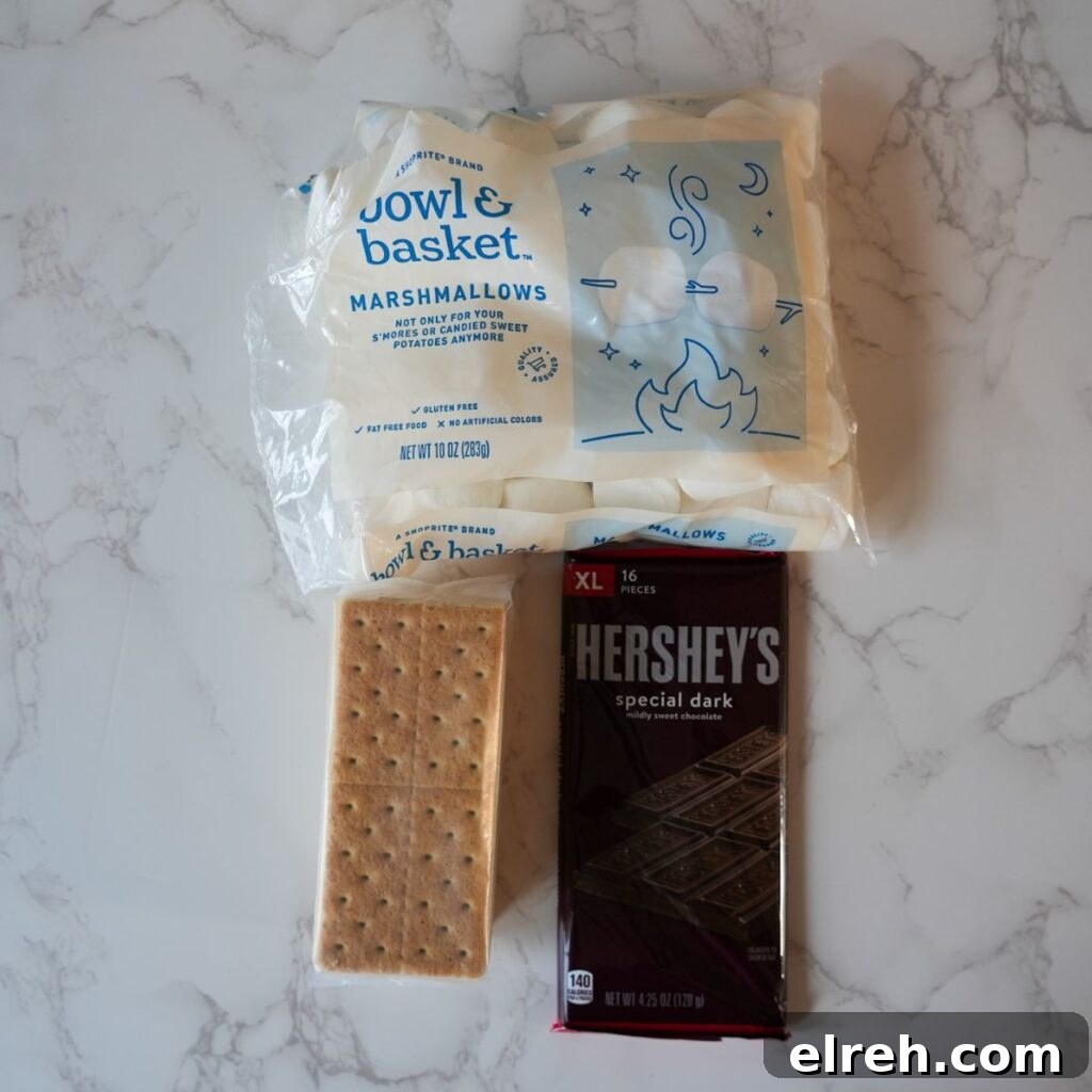 Close-up of ingredients for s'mores dip: marshmallows, chocolate, and graham crackers.