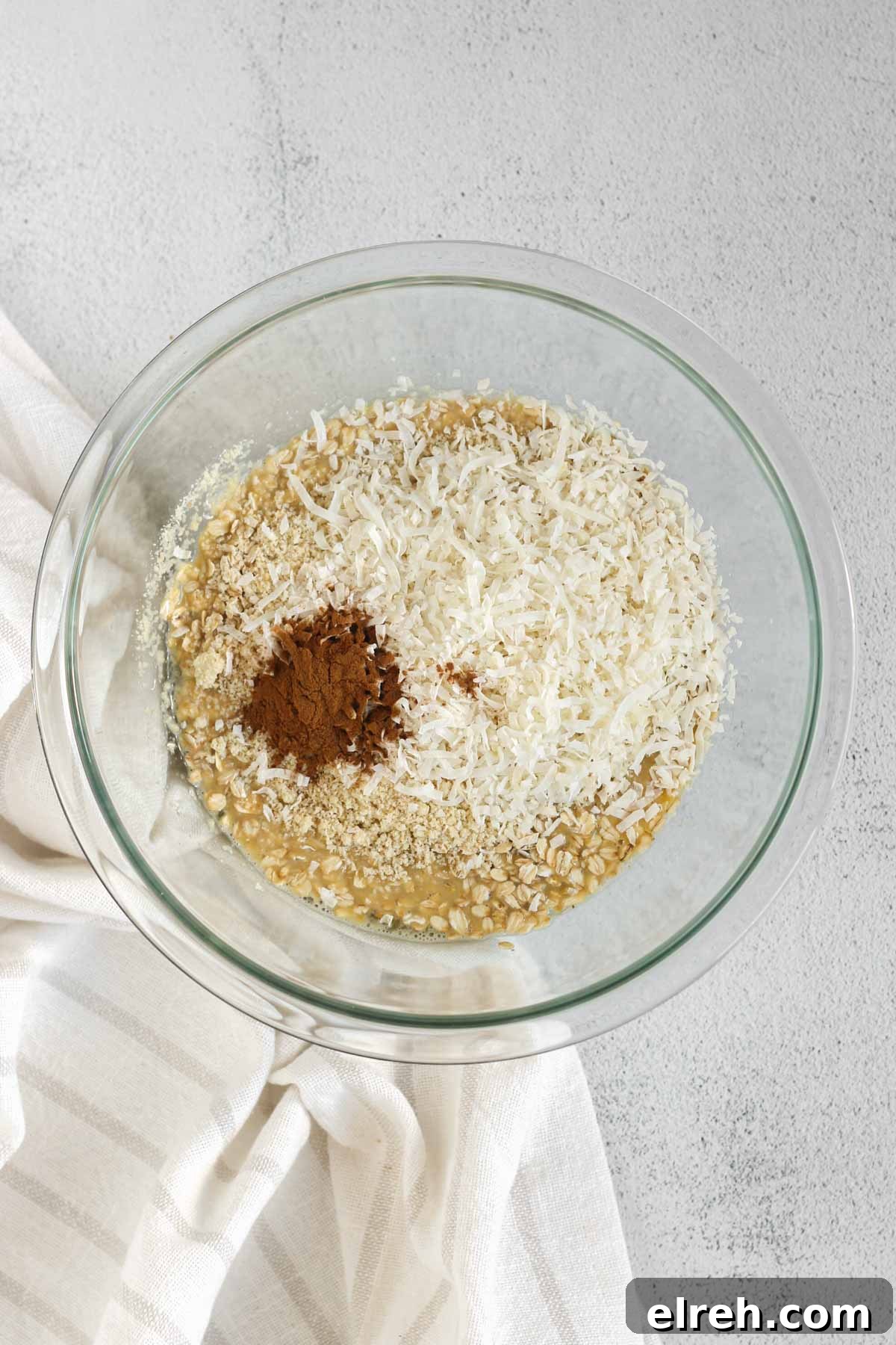 Cranberry Apple Breakfast Cookies Recipe 4 Whisked eggs and milk with oats, cinnamon, coconut and almond flour added to the top, all in a glass mixing bowl.