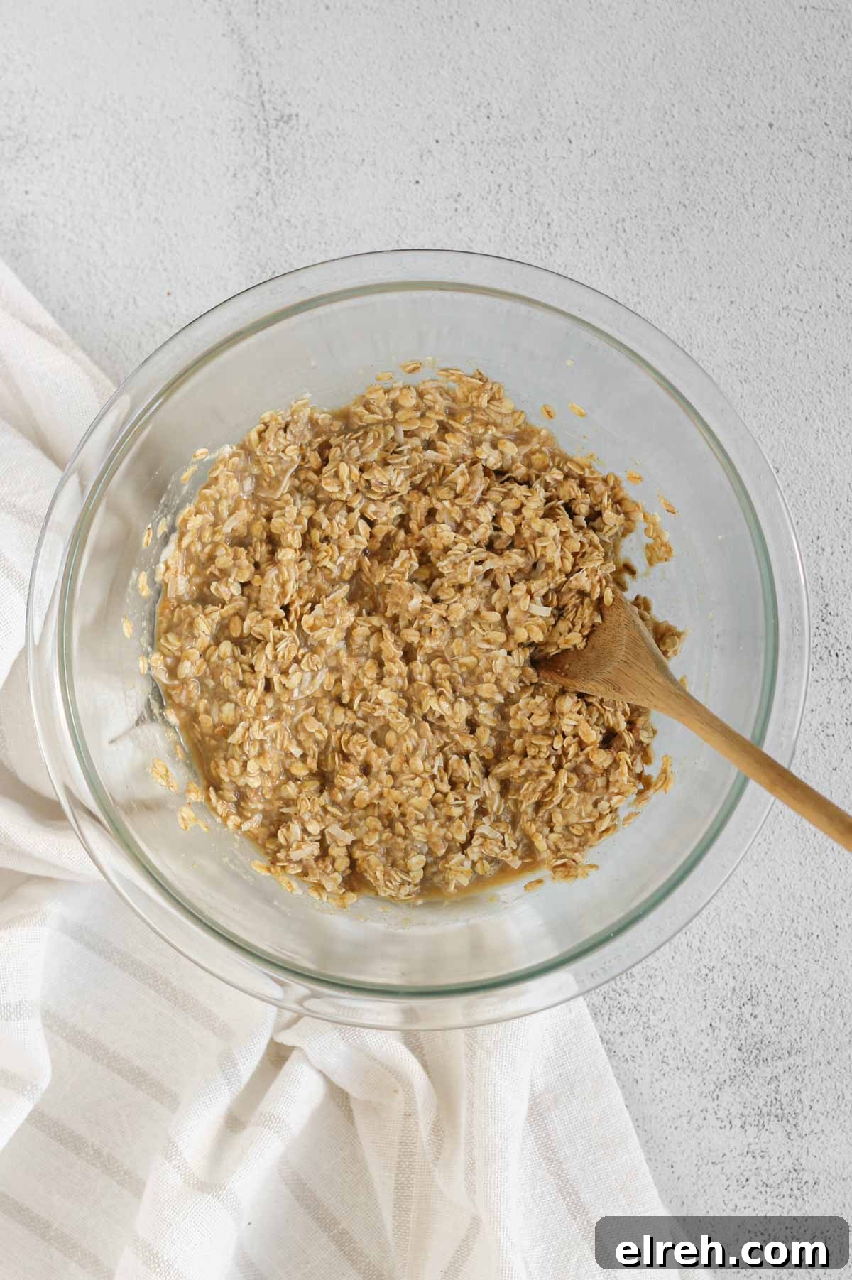 Cranberry Apple Breakfast Cookies Recipe 5 Breakfast cookie mix base in a glass mixing bowl with a wooden spoon.