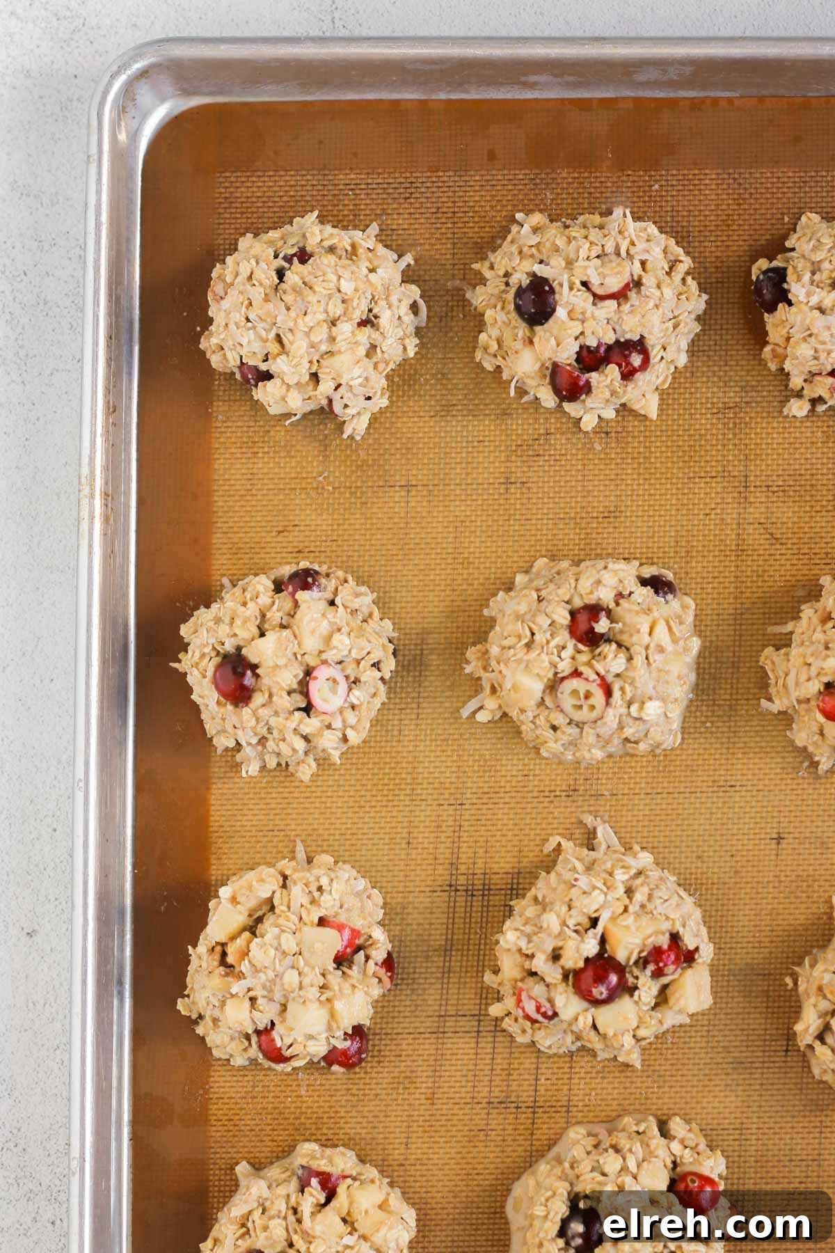 Cranberry Apple Breakfast Cookies Recipe 8 Cranberry apple breakfast cookies unbaked dough on a cookie sheet lined with a silicone baking mat.