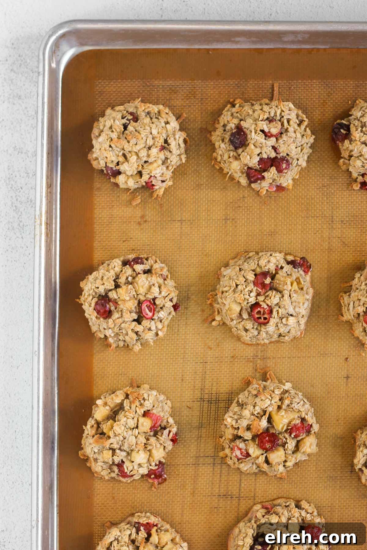 Cranberry Apple Breakfast Cookies Recipe 9 Cranberry apple breakfast cookies baked on a cookie sheet lined with a silicone baking mat.