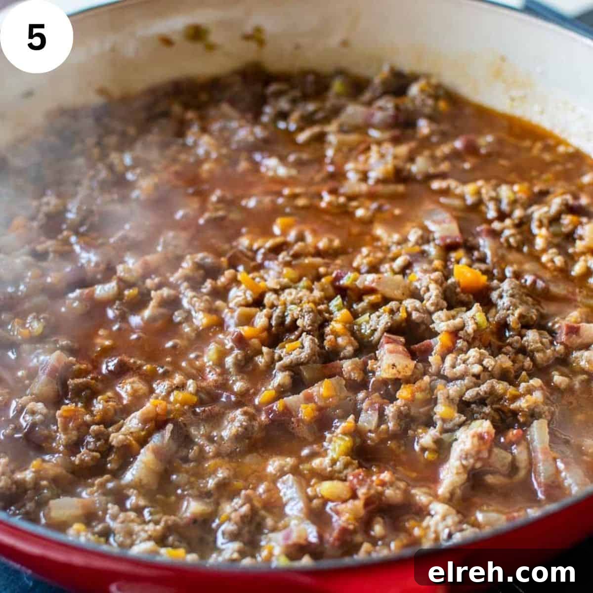 Authentic Tagliatelle with Bolognese Sauce Recipe 8 Ground meat simmering in sauce in a round pan.