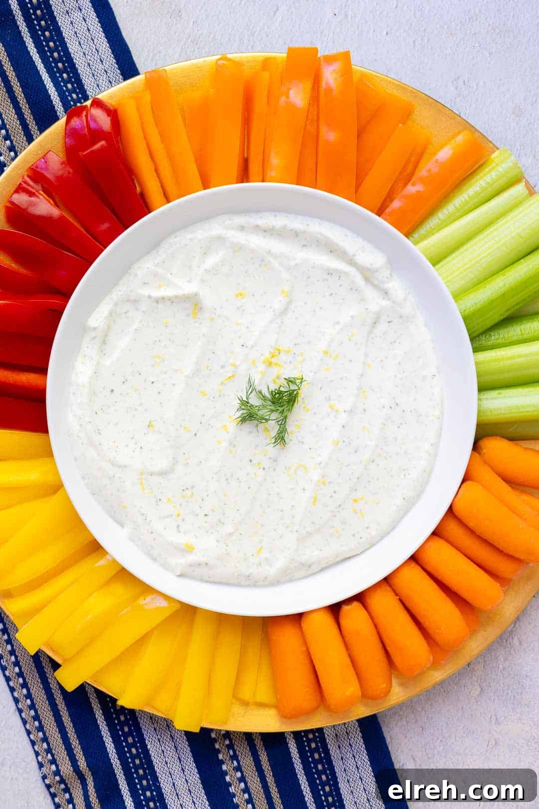 Creamy cottage cheese ranch dip on a serving platter with fresh veggies including red bell peppers and carrots.