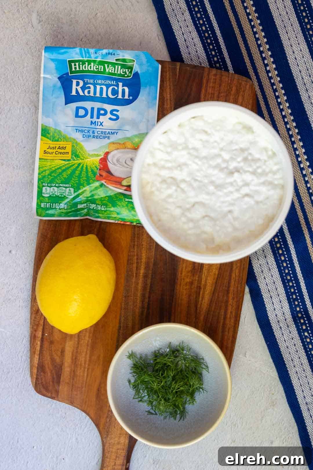 Cottage cheese ranch dip ingredients: cottage cheese, ranch dip mix, fresh dill, and lemon.