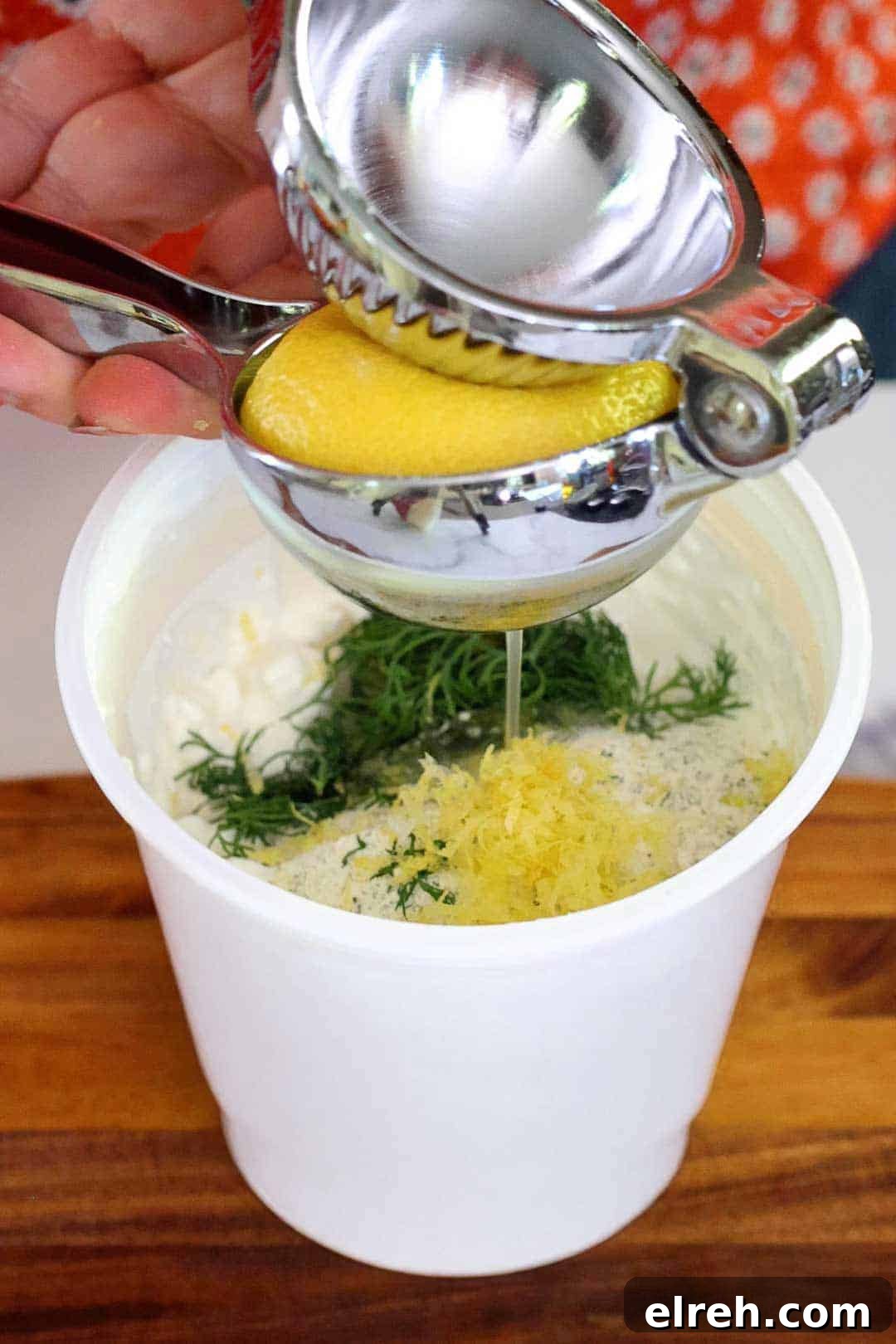 Juicing a lemon and adding cottage cheese ranch dip ingredients directly into the cottage cheese container.