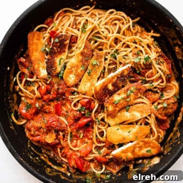 Halloumi pasta with tomatoes and spaghetti in a skillet.
