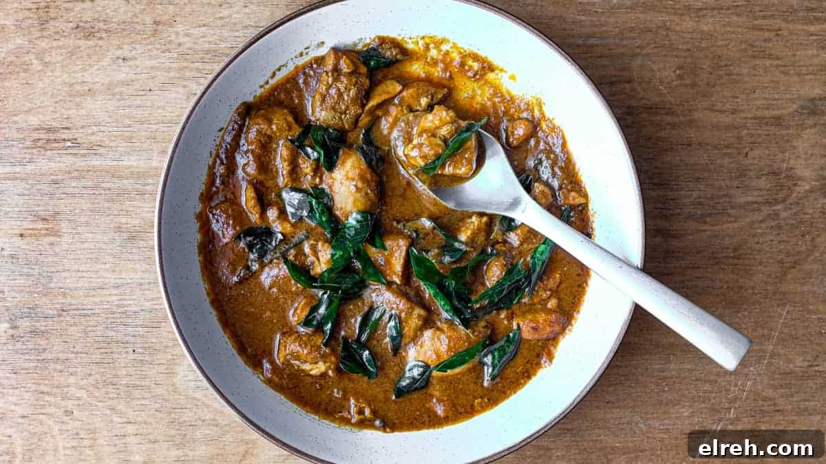 A bowl of Chicken Madras Curry scattered with fried curry leaves