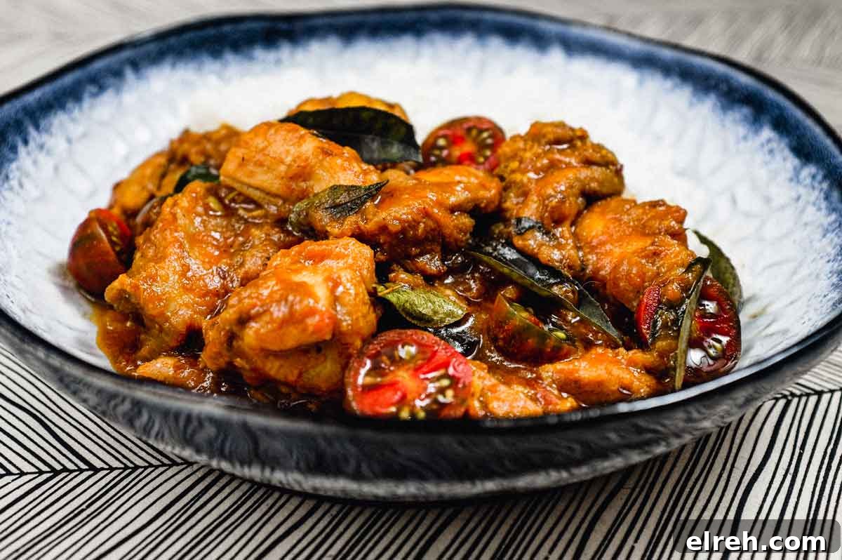 A bowl of chicken chukka curry with rice.