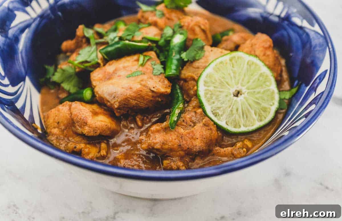 A blue bowl containing Keralan Chicken Curry (Nadan Khozi)