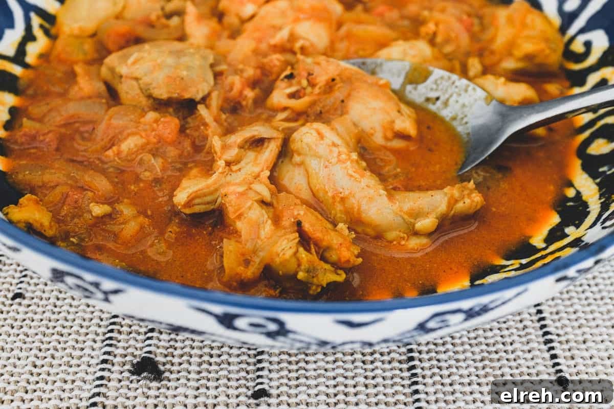 Chicken cooked with vinegar. spices, garlic and tomato.